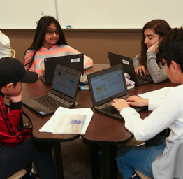 students gathered around table
